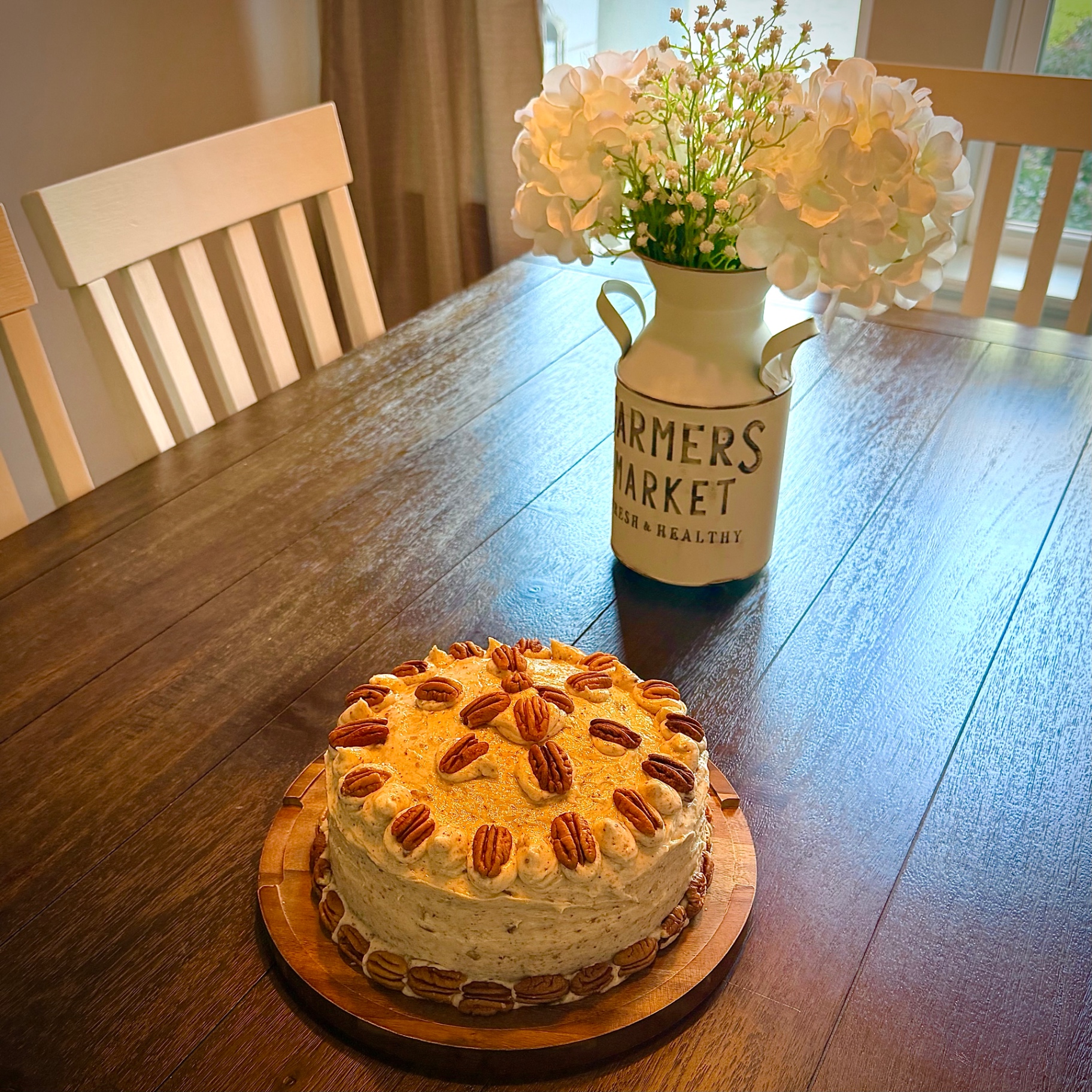 Not-So-Red Velvet Cake with cream cheese frosting and pecan halves on a wooden board