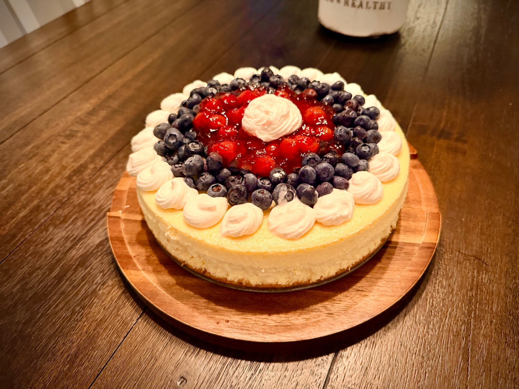 Close-up of Classic Cheesecake with berry topping and piped whipped cream border